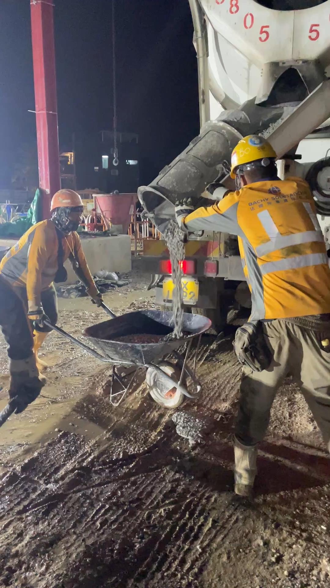Workers placing GGBS concrete at night