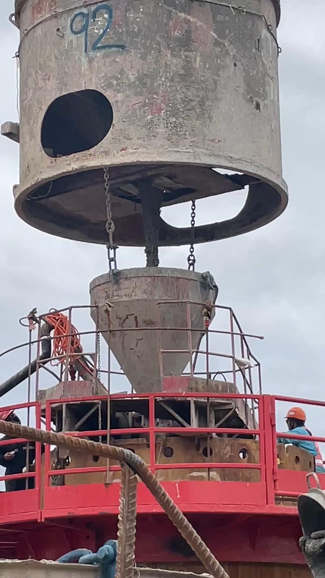 Tremie hopper placing concrete on the trial pile